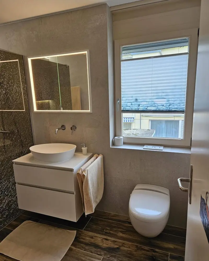 Modernes Badezimmer mit freistehender Badewanne und dunklen Fliesen